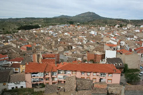 Blick auf Dächer und Häuser in Ayora, Valencia, mit Hügeln im Hintergrund.