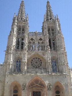 Facade of Burgos Cathedral with Gothic towers and central rose window.