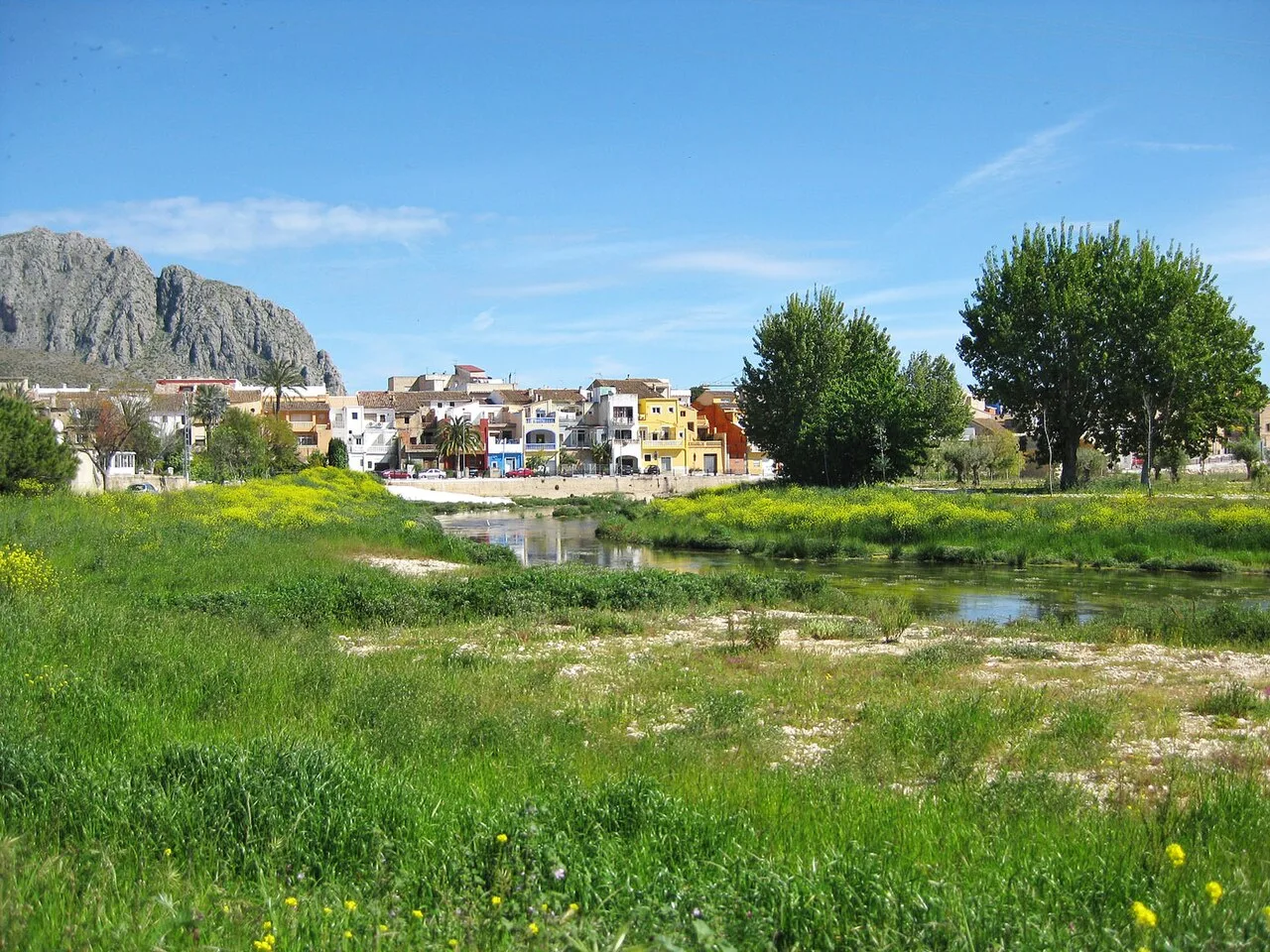Aussicht auf den Fluss Girona, Beniarbeig und das Segària-Gebirge mit Bäumen und Häusern.