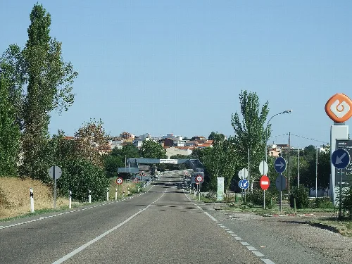 Straße in Peraleda de la Mata mit Bäumen und Verkehrsschildern.