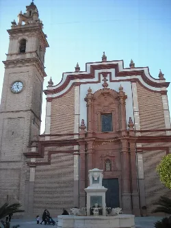 Church facade with fountain and bell tower in Foyos