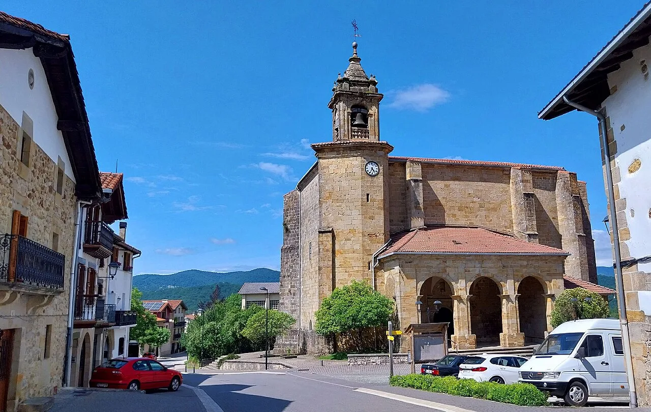 Kirche mit Turm und Uhr auf dem Dorfplatz von Urdiáin, Navarra.