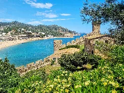 Walls and greenery in the historic center of Tossa de Mar with sea view.