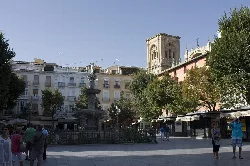 Neptune Fountain in Bib-Rambla Square with trees and historic buildings.
