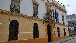 Fassade des Rathauses von Arjona mit Flaggen an der Hauptfassade.