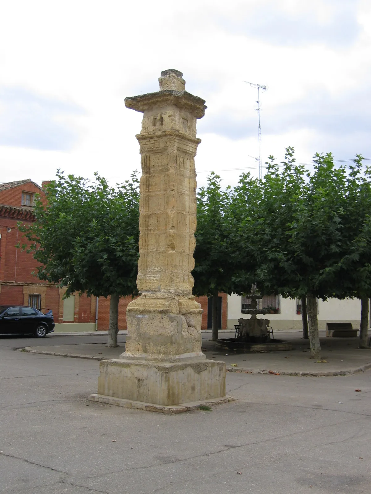 Steinsäule in einem Platz mit Bäumen und Bänken in Itero de la Vega.