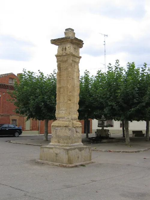 Stone pillar in a square with trees and benches in Itero de la Vega.