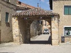 Arco de piedra con tejado de tejas en Coruña del Conde.