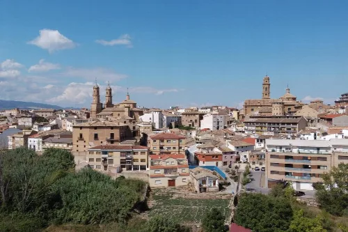 Vista de Corella con iglesias y edificios históricos en el centro.