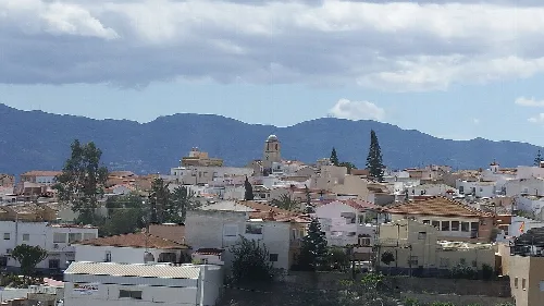 Paisaje urbano de Antas con montañas y casas.