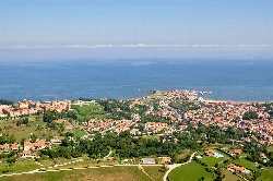 Vista aérea de Comillas con mar y pueblo en primer plano.