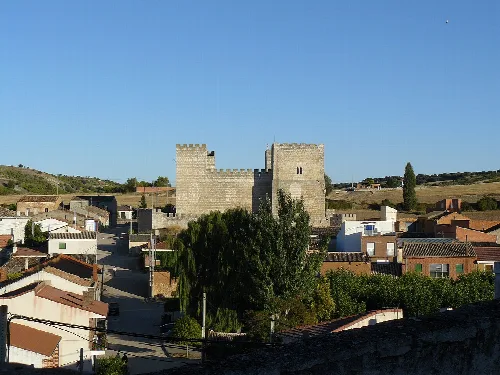 Torre y casas en Encinas de Esgueva, Valladolid, con cielo azul.