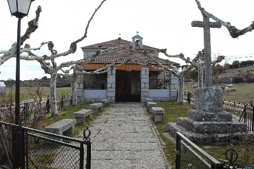 Pequeña ermita con cruz de piedra y árboles sin hojas en La Cabeza de Béjar.