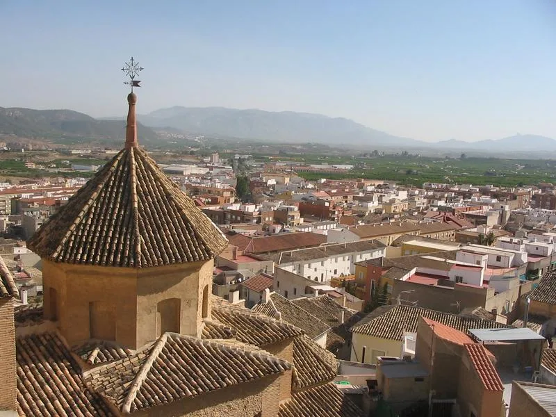 Vista de tejados y ciudad de Mula con montañas al fondo.