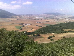 Paisaje del valle de Elorz con campos y montañas en el fondo.
