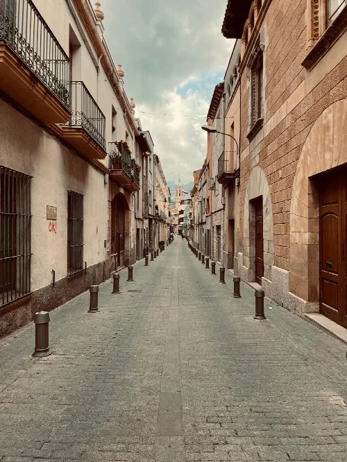 Enge Straße mit alten Gebäuden und Balkonen in Esparraguera.