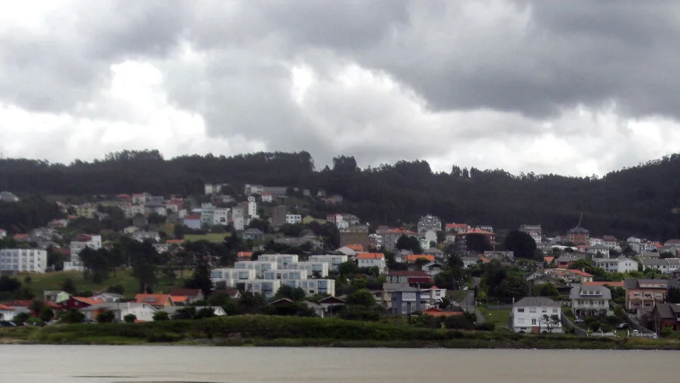 Houses and hills in Valdoviño with cloudy sky.