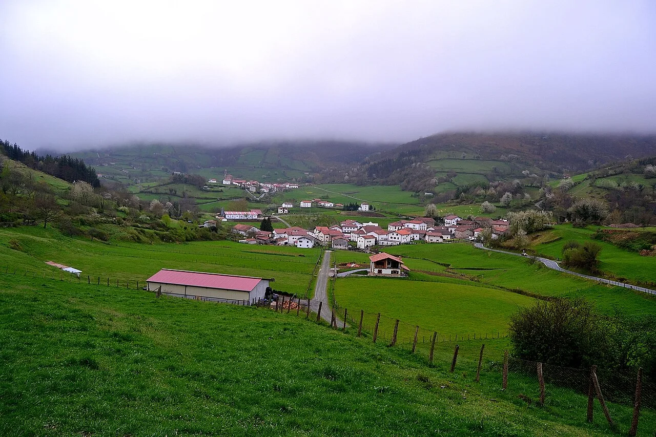 Paisaje rural con casas, colinas y cielo nublado en Beintza-Labaien, Navarra.