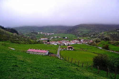 Ländliche Landschaft mit Häusern, Hügeln und bewölktem Himmel in Beintza-Labaien, Navarra.