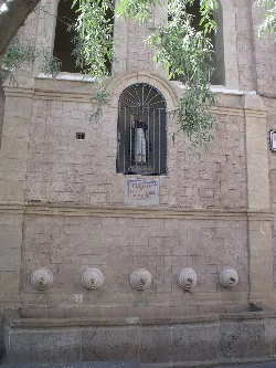 Fuente con estatua en ventana y bocas de agua en Yátova.