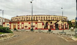 Almendralejo bullring, circular building with red and beige decorations.