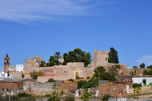 View of Luna Castle with stone walls and towers in Mairena del Alcor.