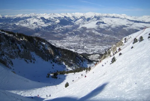 Blick auf die Coma Oriola Schlucht und schneebedeckte Berge bei Masella, Girona.