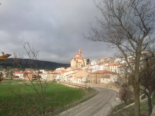 Blick auf eine Stadt mit Kirche auf einem Hügel und alten Häusern in der Nähe.