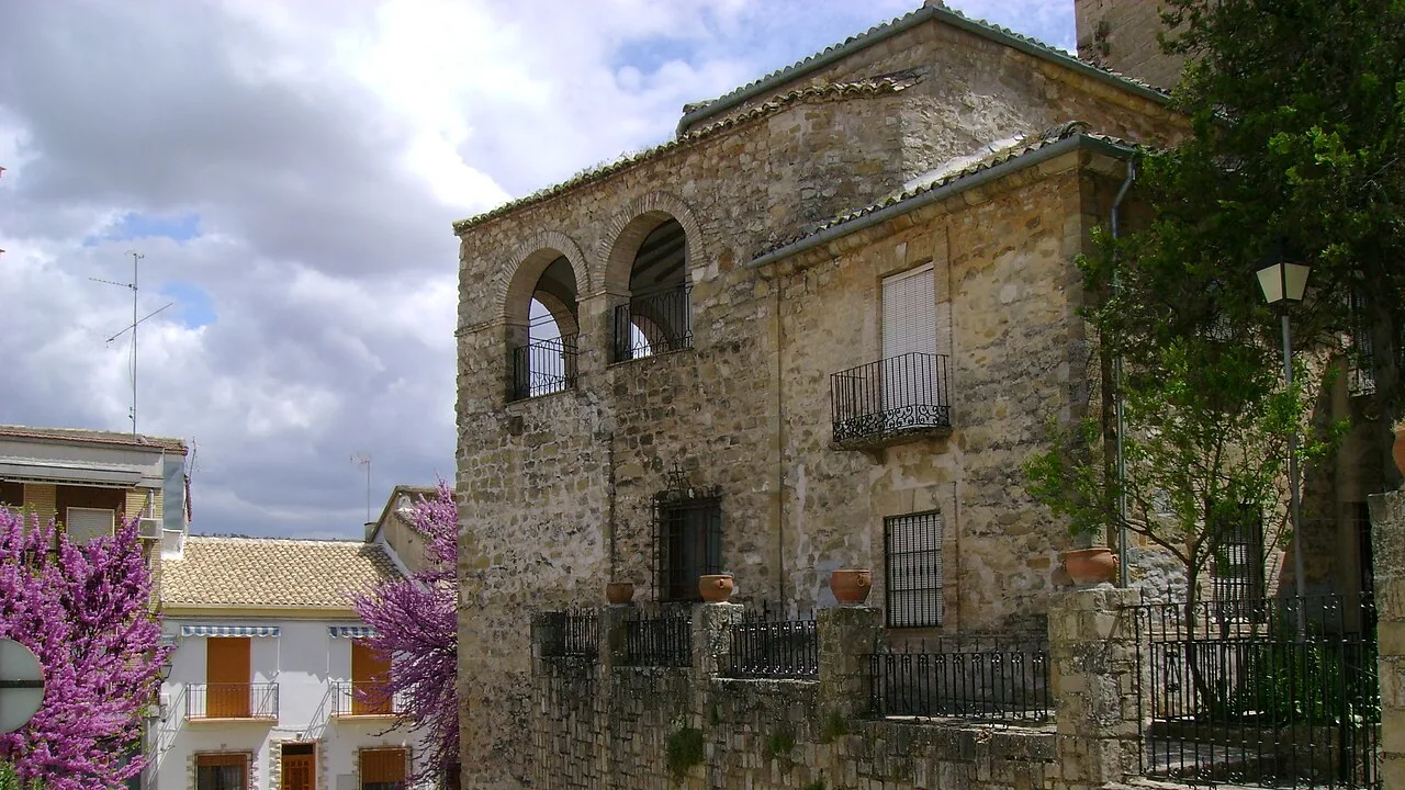 Stone church facade with arches and windows in Villanueva del Arzobispo.