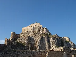 Vista del castillo de Morella sobre una roca con cielo azul.