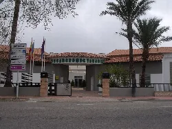 Town hall building with palm trees and signage at the entrance.