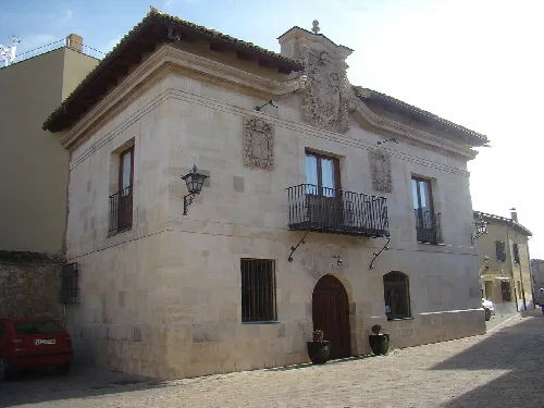 Edificio de piedra con balcón y puertas en Valoria la Buena.