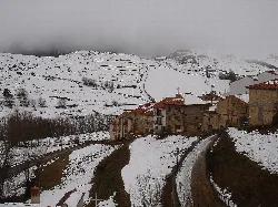 Casas y caminos cubiertos de nieve en Valdelinares, Teruel.