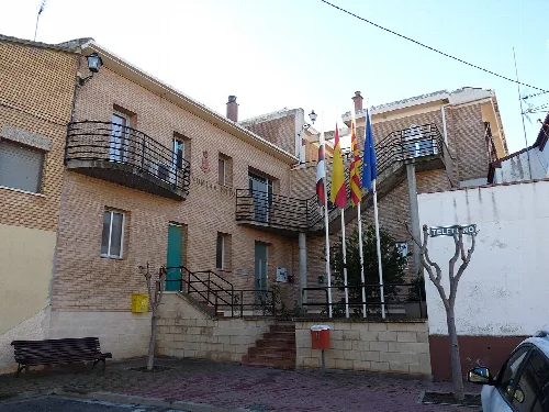 Rathausgebäude mit Flaggen und Treppen in Poleñino.