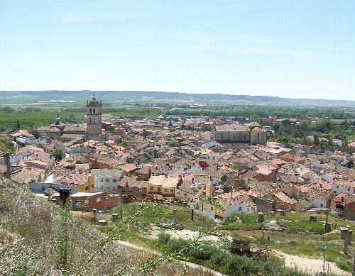 Panoramic view of Dueñas with church and rural landscape.