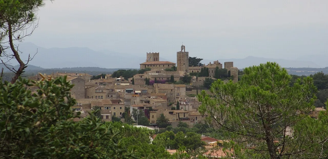 Vista de Pals con edificios antiguos y un castillo en la cima.