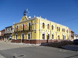 Edificio del ayuntamiento de Matapozuelos con fachada amarilla y detalles clásicos.