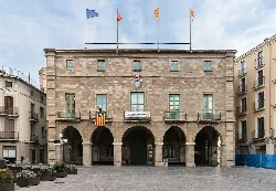 Stone building with arches and flags on the roof, in Manresa, Catalonia.