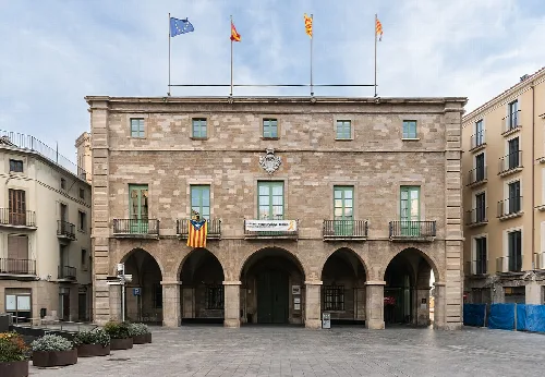 Steinernes Gebäude mit Bögen und Flaggen auf dem Dach, in Manresa, Katalonien.