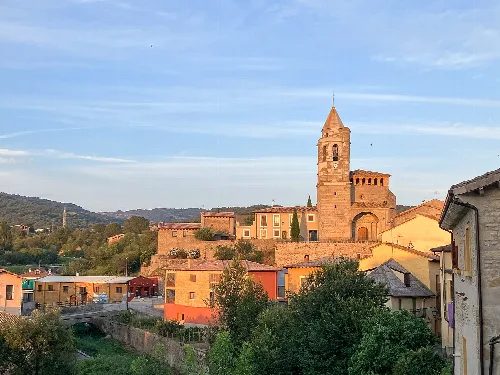 Blick auf eine Stadt mit Backsteinkirche und bunten Häusern in einer ländlichen Landschaft.