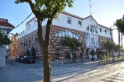 Edificio blanco con fachada moderna y árboles en la calle en El Cuervo de Sevilla.