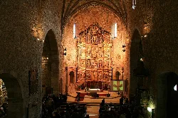 Interior of a church with a Baroque altarpiece at the main altar.