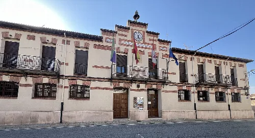 Town hall building with flags and clock on the facade.