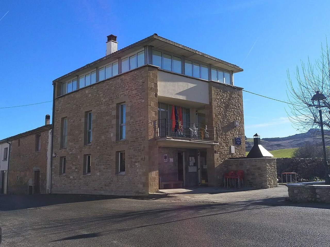 Edificio del ayuntamiento de Zabalza con fachada de piedra y ventanas grandes.