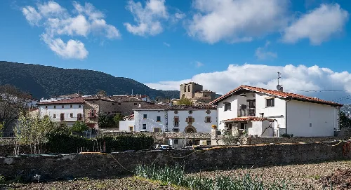 White houses in Belascoáin with mountains in the background.