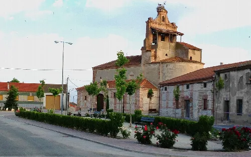 Main square of Martín Muñoz de la Dehesa with church and trees.
