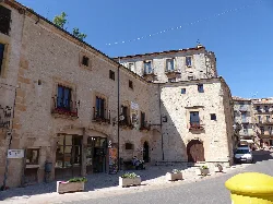 Steinernes Gebäude mit kleinen Fenstern und einer gewölbten Tür in Sepúlveda.