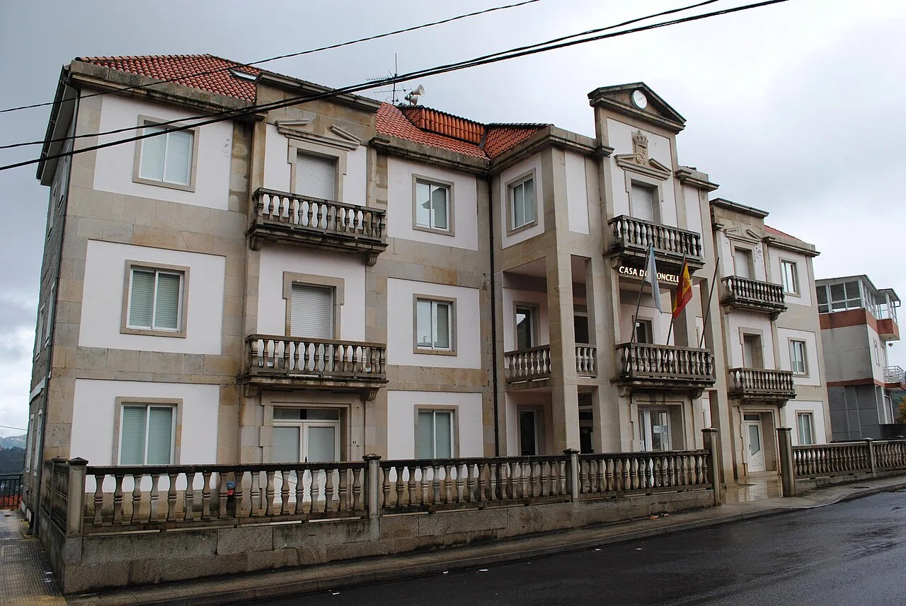 Multi-story building with balconies and a flag on the facade.
