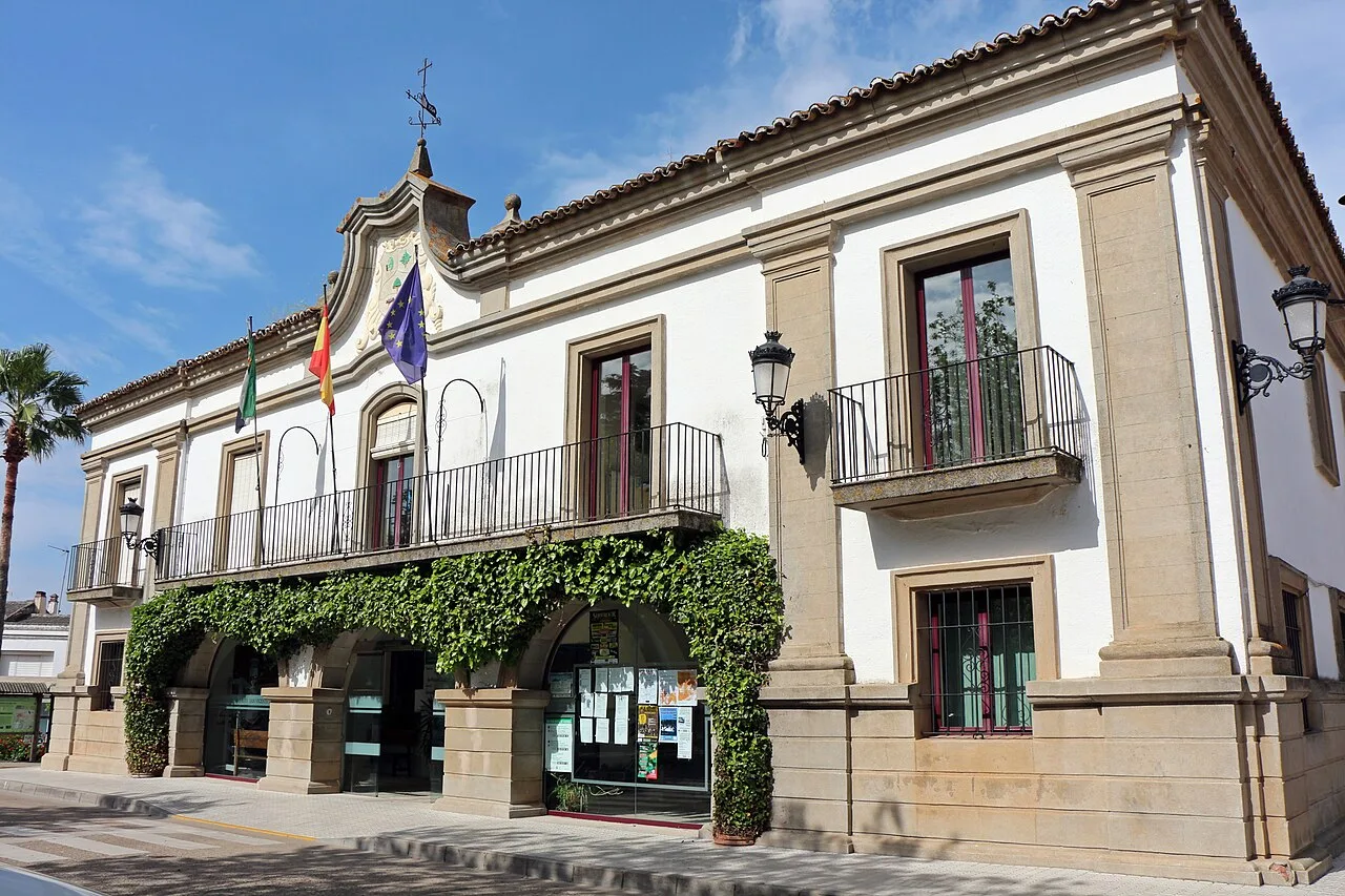 Town hall building with flags and greenery on the facade.