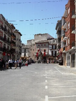 Plaza mayor con edificios y personas en Fuente la Higuera.
